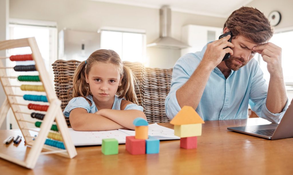 A father researching options while his daughter sits nearby
