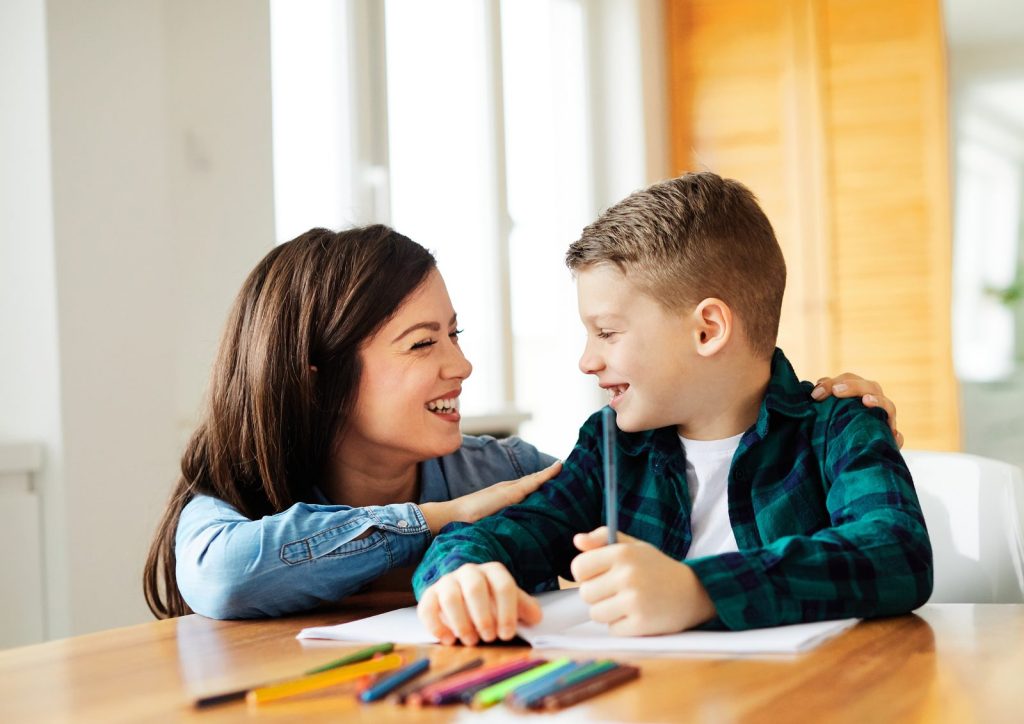 A mother and her son drawing together at home