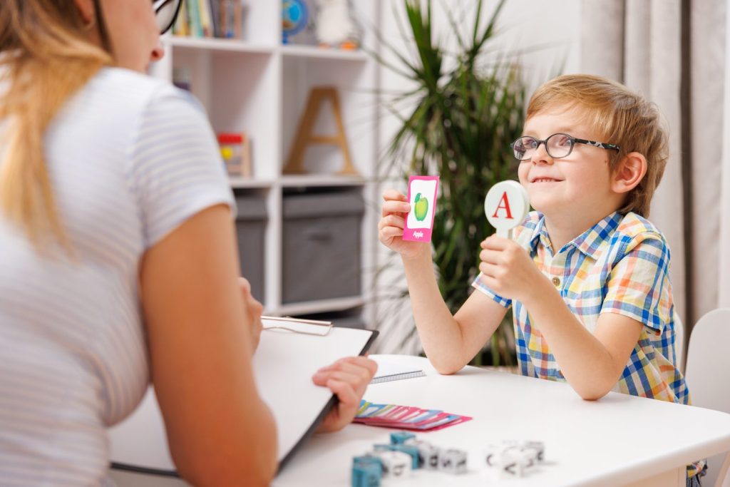 A boy learning the alphabet with an instructor